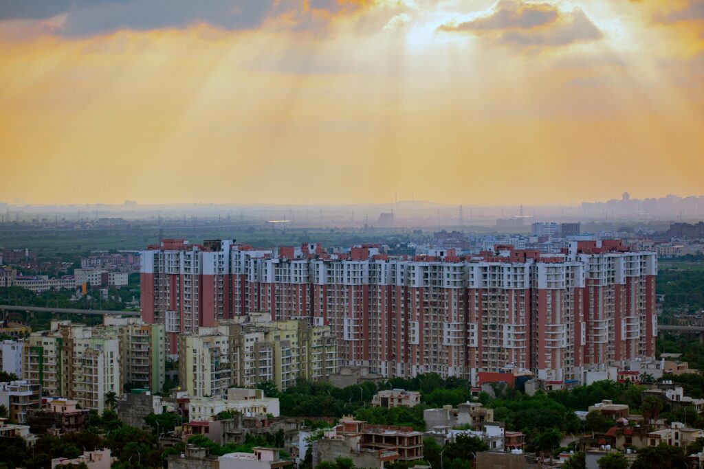 pexels-photo-15059576-15059576 Captivating aerial view of Noida's residential skyline at sunrise, showcasing modern architecture and dramatic skies.